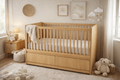 Cuna de madera roble natural y blanco con cajones inferiores en habitación infantil estilo cozy neutro en México.